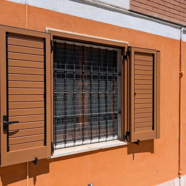 Inferriata di sicurezza in ferro su finestra con persiane