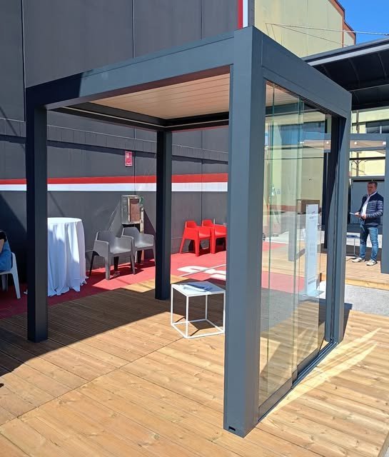Pergola bioclimatica in alluminio con parete vetrata scorrevole