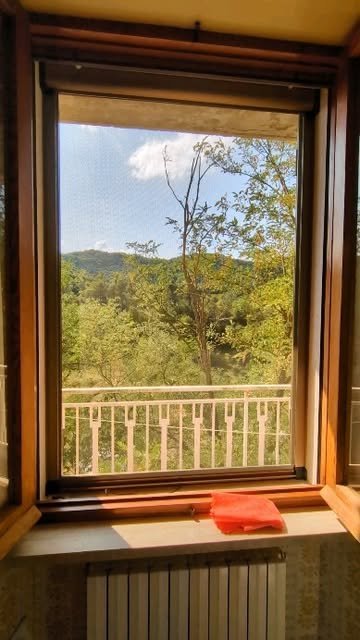 Zanzariera a rullo su finestra in legno, vista sulle colline della Val Vibrata